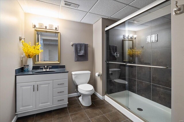 bathroom with toilet, vanity, visible vents, baseboards, and a shower stall