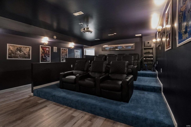 home theater room featuring wood finished floors and baseboards