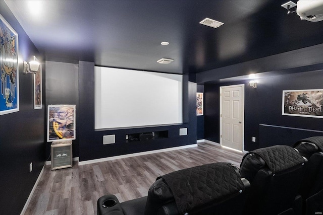 home theater featuring visible vents, baseboards, and wood finished floors