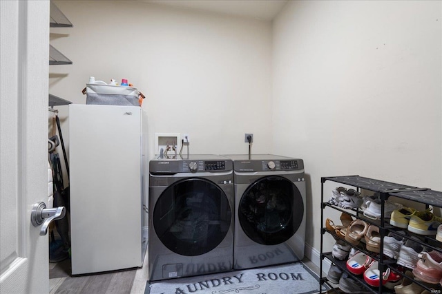 laundry area featuring laundry area, washing machine and dryer, and wood finished floors