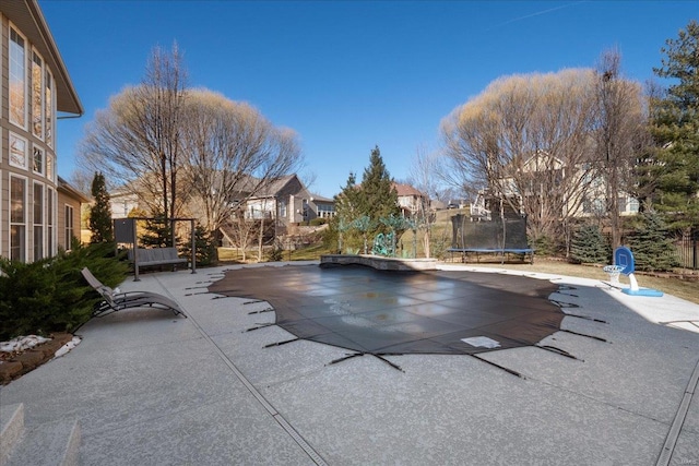 view of pool with a patio and a trampoline