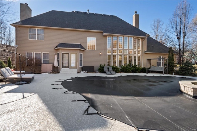 back of house with a patio and a chimney