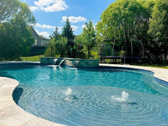 outdoor pool with a trampoline and fence