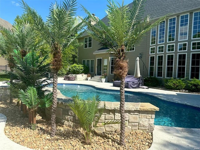 outdoor pool featuring entry steps, a patio area, fence, and an outdoor hangout area