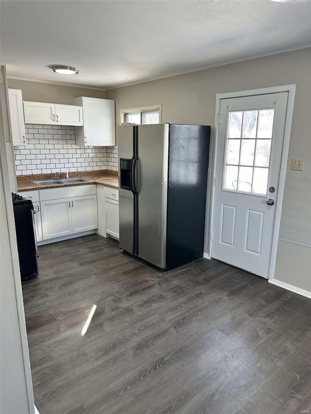 kitchen with dark wood-style flooring, tasteful backsplash, white cabinets, a sink, and stainless steel fridge