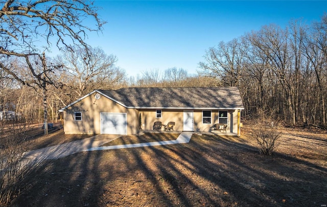 view of front facade featuring an attached garage and dirt driveway