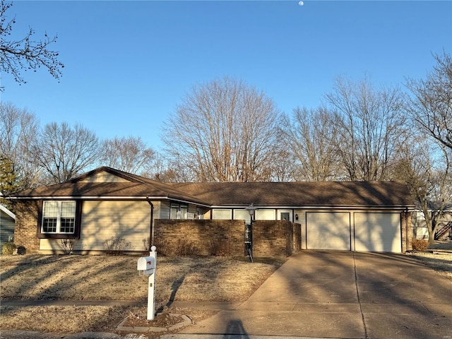 ranch-style home featuring concrete driveway, an attached garage, and brick siding