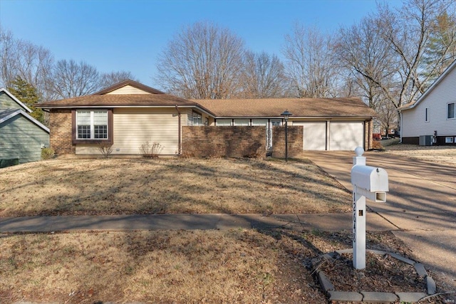 ranch-style house with a garage, central AC unit, and driveway