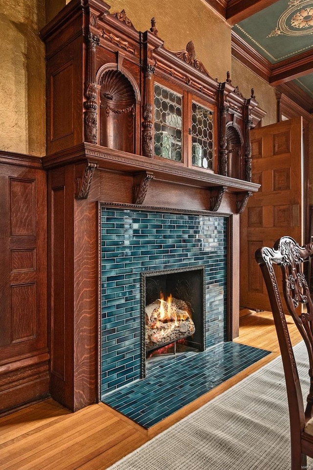 room details with a fireplace, ornamental molding, and wood finished floors