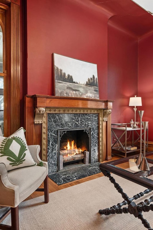 sitting room with a fireplace and wood finished floors