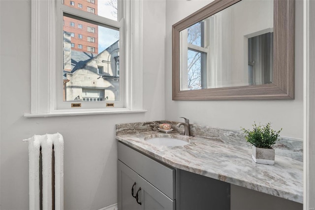 bathroom featuring radiator, plenty of natural light, and vanity