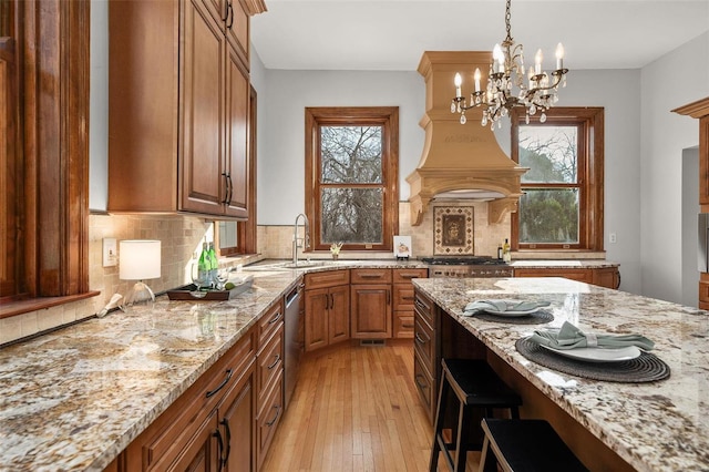 kitchen with a wealth of natural light, appliances with stainless steel finishes, brown cabinetry, and a sink