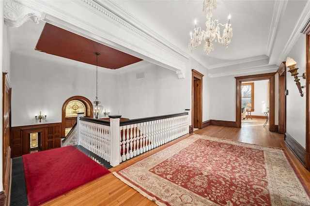 interior space featuring a chandelier, visible vents, ornamental molding, and hardwood / wood-style floors