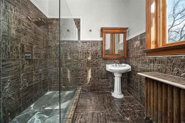 bathroom featuring tiled shower and tile walls