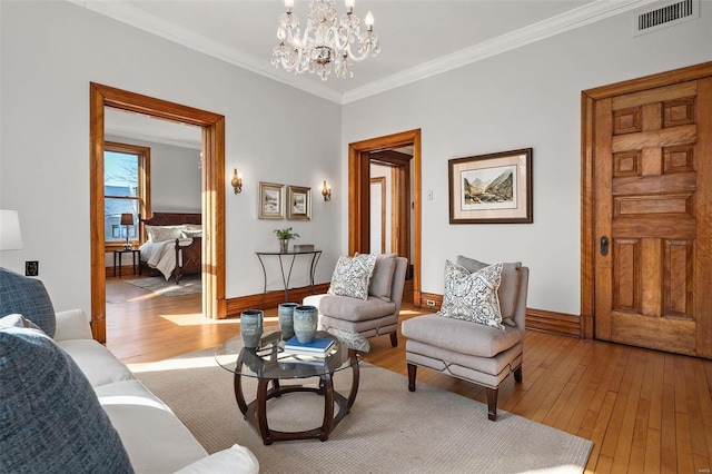 living room featuring light wood finished floors, baseboards, visible vents, crown molding, and a chandelier