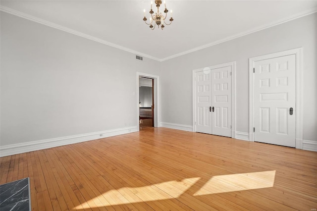 unfurnished bedroom with light wood finished floors, visible vents, a chandelier, and ornamental molding