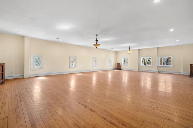 unfurnished living room with recessed lighting, light wood-style flooring, and baseboards