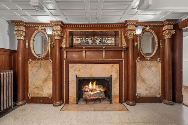 interior space featuring a premium fireplace, radiator heating unit, and decorative columns