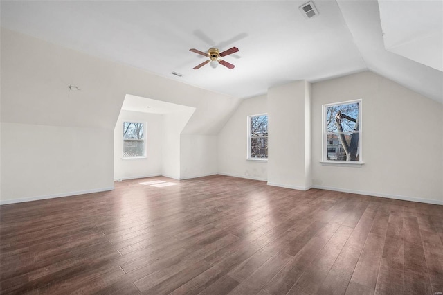 additional living space with lofted ceiling, visible vents, baseboards, and wood finished floors