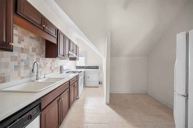 kitchen with white appliances, a sink, light countertops, decorative backsplash, and washer and clothes dryer