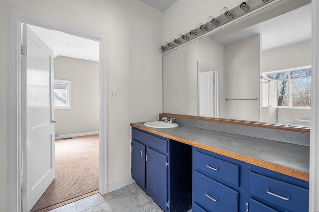 bathroom with marble finish floor, vanity, and baseboards