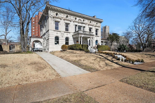 italianate-style house with driveway and a balcony