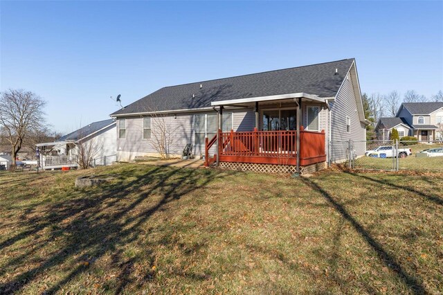 back of house with a shingled roof, a lawn, fence, and a wooden deck