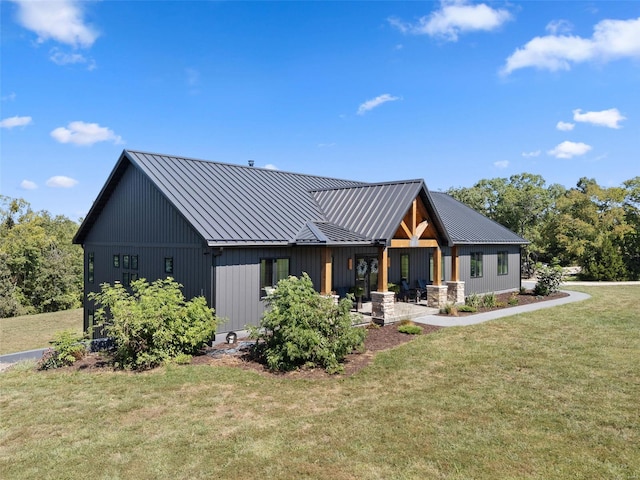 view of front of home with metal roof, a standing seam roof, and a front yard