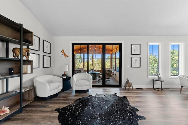 living area with vaulted ceiling, dark wood finished floors, and baseboards