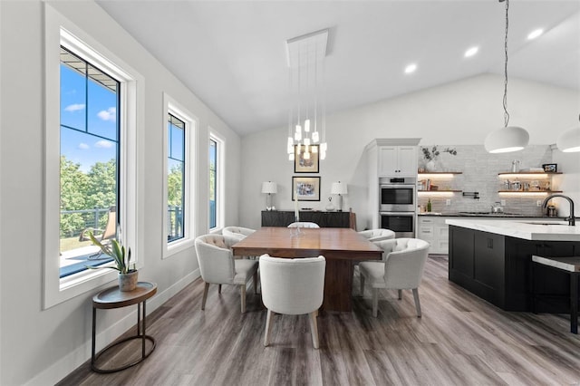 dining room featuring lofted ceiling, recessed lighting, baseboards, and wood finished floors