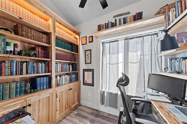 office area featuring lofted ceiling, light wood-type flooring, baseboards, and plenty of natural light