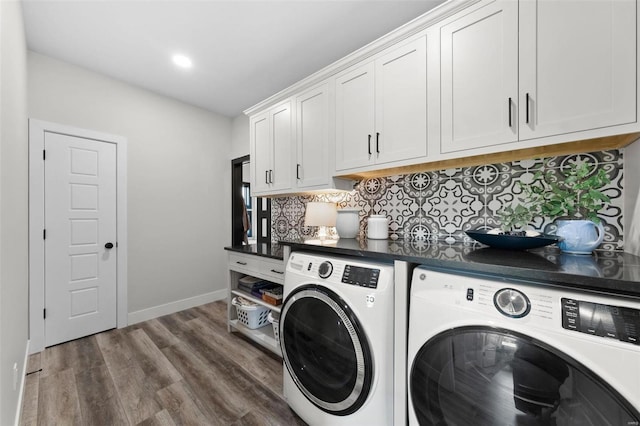 washroom featuring cabinet space, washing machine and dryer, dark wood finished floors, and baseboards