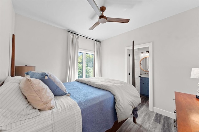 bedroom featuring dark wood-style floors, ceiling fan, baseboards, and ensuite bathroom