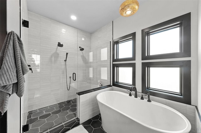 full bath featuring a freestanding tub and a shower stall