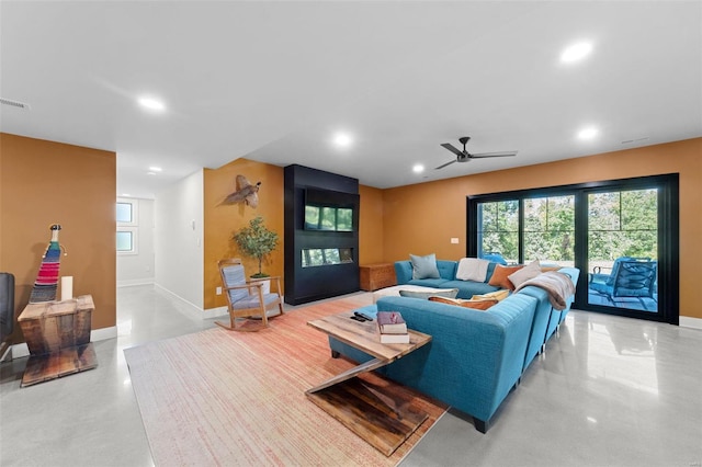 living area featuring baseboards, ceiling fan, concrete flooring, and recessed lighting