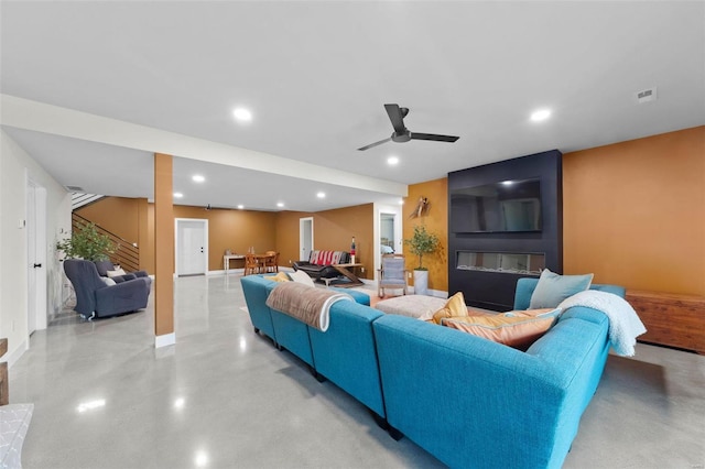 living area with finished concrete flooring, stairs, visible vents, and recessed lighting