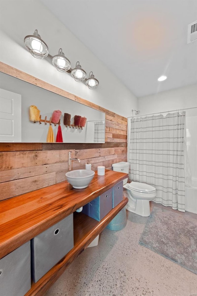 bathroom featuring toilet, speckled floor, vanity, visible vents, and shower / bath combo