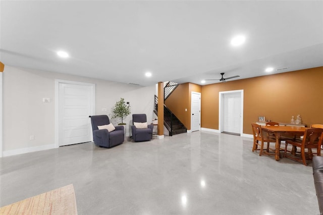 living area featuring concrete flooring, recessed lighting, baseboards, and stairs