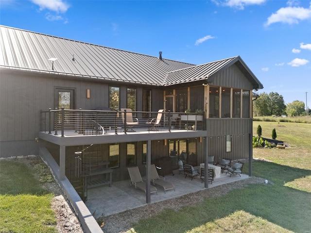 back of house with metal roof, a patio, a yard, and a standing seam roof