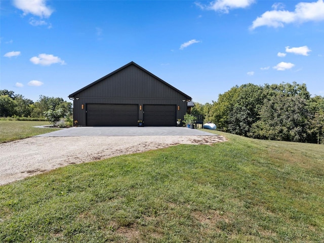 view of home's exterior with a yard and a detached garage