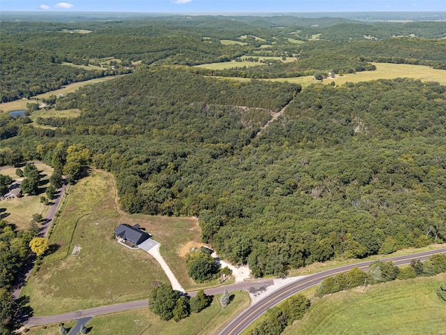 drone / aerial view featuring a wooded view