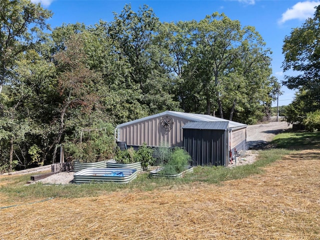 view of yard featuring an outdoor structure and a garden