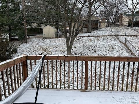 snow covered deck with an outbuilding and a shed