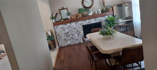 dining space with a fireplace and wood finished floors