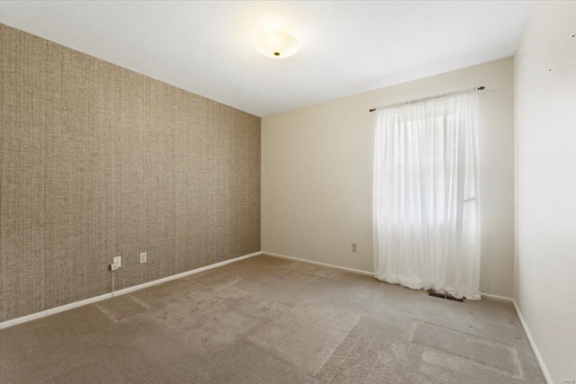 unfurnished room featuring carpet flooring, baseboards, and visible vents