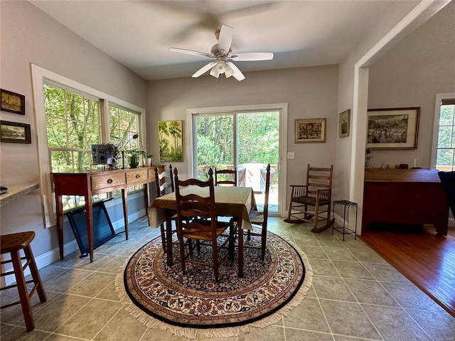 dining room featuring ceiling fan, plenty of natural light, tile patterned flooring, and baseboards