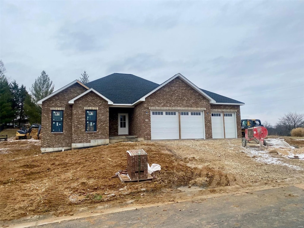 view of front facade with a garage, brick siding, driveway, and roof with shingles