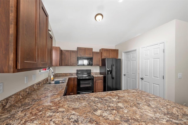 kitchen featuring a sink, black appliances, and light stone countertops