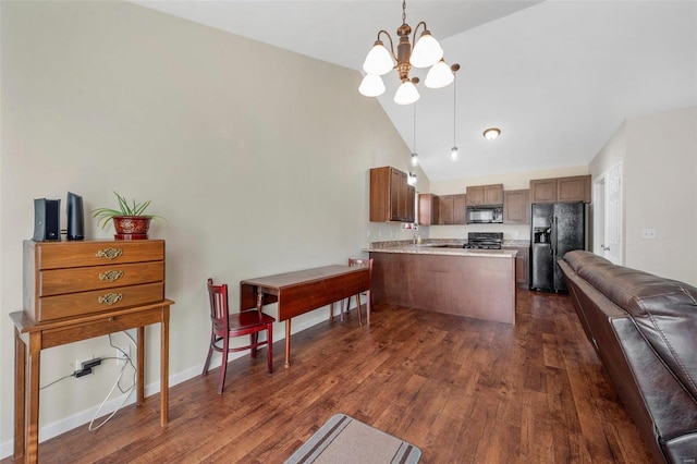 kitchen with dark wood-style floors, open floor plan, a peninsula, light countertops, and black appliances