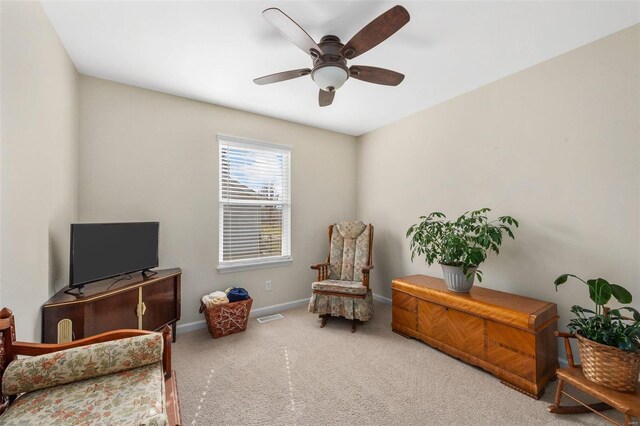 living area with carpet, visible vents, baseboards, and ceiling fan